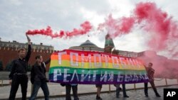 Gay rights activists hold a banner reading 'Homophobia - the religion of bullies' during their action in protest of homophobia on Red Square in Moscow, Russia, July 14, 2013.