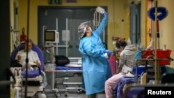 A medical worker is seen as patients suffering with the coronavirus disease are treated in the emergency room of the Maggiore di Lodi hospital, in Lodi, Italy, Nov. 13, 2020. 