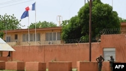 FILE — Officers of the Niger national Police are seen outside the French Embassy in Niamey, Aug. 28, 2023.