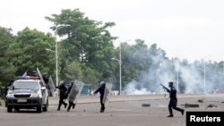 Congolese policemen run to their vehicle during a clash with opposition activists participating in a march to press President Joseph Kabila to step down in the Democratic Republic of Congo's capital Kinshasa, Sept. 19, 2016. 