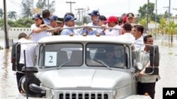 Handout photo released by Mexican Presidency of Mexican President Felipe Calderon (C-L) as he visits the area affected by Hurricane Karl in Veracruz, Mexico on 20 Sept 2010.