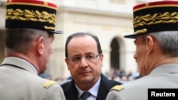 France's President Francois Hollande (C) speaks to military officials as he attends a ceremony to the memory of Stephane Hessel, at the Invalides in Paris, March 7, 2013.