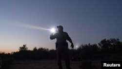 Un agente de la patrulla estatal de Texas hace guardia en la frontera, en busca de migrantes irregulares que intentan cruzar el río Grande, el 8 de abril de 2021. 