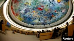 FILE - Wu Hailong, special envoy of China's Foreign Ministry (L), addresses the Human Rights Council Universal Periodic Review session at the European headquarters of the United Nations in Geneva, Oct. 22, 2013. 