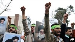 Demonstrators shout slogans and hold portraits of Iranian supreme leader Ayatollah Ali Khamenei (C) and founder of the Islamic republic Ayatollah Ruhollah Khomeini (2nd L) during a protest outside the Italian embassy in Tehran, 09 Feb 2009
