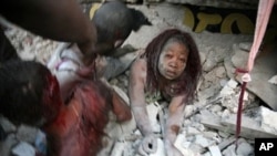 Haitian woman is covered in rubble in Port-au-Prince, 12 Jan 2010