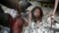 Haitian woman is covered in rubble in Port-au-Prince, 12 Jan 2010