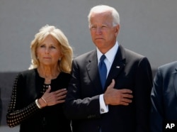 Former Vice President Joe Biden, right, and his wife Jill Biden, pause with hands over their hearts as they watch a military honor guard place the casket of Sen. John McCain, R-Ariz., into a hearse after a memorial service at North Phoenix Baptist Church,