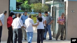 Unidentified people enter the municipal court for the trial of US citizen Alan Gross, charged with espionage, on March 4, 2011 in Havana