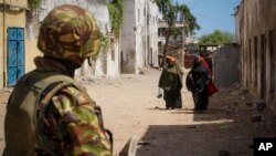 A soldier of the Kenyan Contingent serving with the African Union Mission in Somalia (AMISOM) stand guard on a street in the centre of the southern Somali port city of Kismayo. The mandate for AMISOM was recently extended.