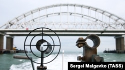 UKRAINE -- CRIMEA, DECEMBER 5, 2018: A patrol boat of the coast guard of the Border Service under the Russian Federal Security Service approaches the Kerch Strait Bridge linking the Crimean Peninsula and mainland Russia. 