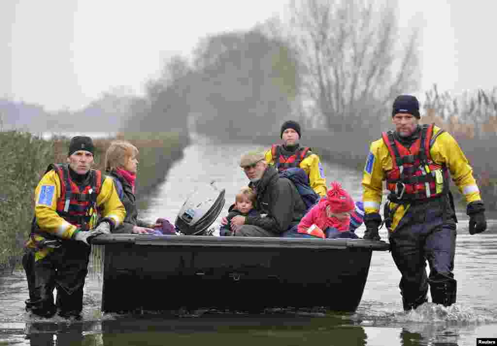 Emergency service personnel rescue local residents from the village of Muchelney on the Somerset Levels, near Langport in south west England. Surrounded by flood water, Muchelney has only been accessible by boat for several weeks.