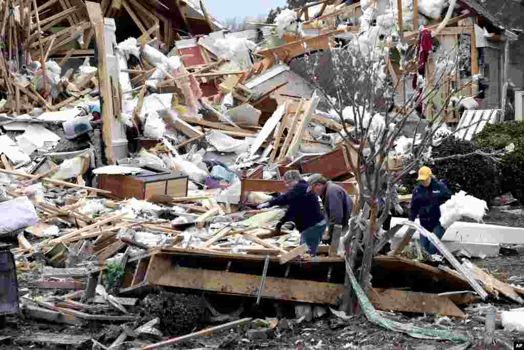 People sift through the rubble of homes at the Ocean Ridge Plantation in Brunswick County, North Carolina, Feb. 17, 2021, after a tornado hit the area Monday night.