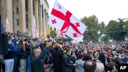 Supporters of the ex-President Mikhail Saakashvili's United National Movement, wave Georgian national flags during rally to protest the election results rally in front of the parliament's building in Tbilisi, Georgia, Nov. 1, 2020.