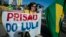 A woman holds a banner reading "Prison for Lula Now" during a demonstration against former President Luiz Inacio Lula da Silva and current President Dilma Rousseff in front of the Criminal Forum in Sao Paulo, Brazil, Feb. 17, 2016. 