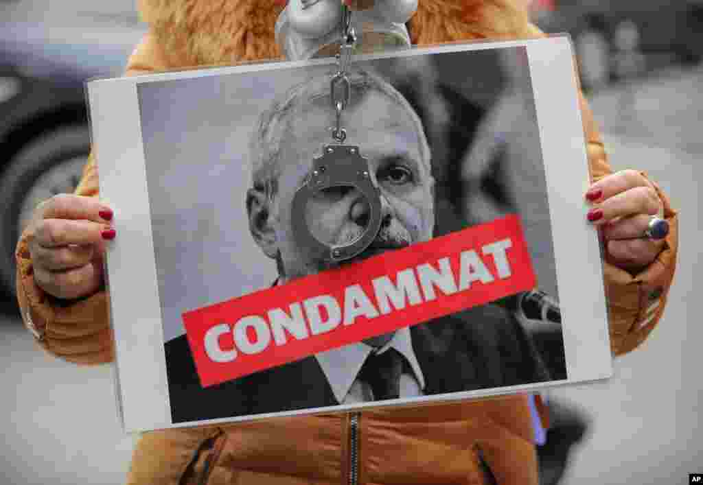 یک معترض در رومانی، در کنار عکس رهبر حزب سوسیال دموکرات، یک دستبند به دست گرفته و اشاره به مبارزه با فساد در این کشور دارد.&nbsp;