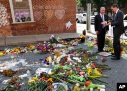Sen. Tim Kaine, left, and Charlottesville mayor Michael Signer visit a makeshift memorial Aug. 16, 2017, where Heather Heyer was killed when a car rammed into a crowd of people protesting a white nationalist rally Charlottesville, Va.