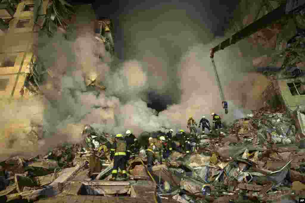Trabajadores de emergencias retiran los escombros luego de que un proyectil ruso impactó contra un edificio de varias plantas, dejando a muchos atrapados bajo los restos, en la ciudad suroriental de Dnipró, Ucrania, el 14 de enero de 2023.&nbsp;