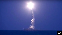In this photo made from the footage taken from Russian Defense Ministry official website, a Russian navy ship on the Caspian Sea launches a cruise missile toward Islamic State targets in Syria, the ministry said, Oct. 7, 2015.