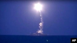 FILE - In this photo made from the footage taken from Russian Defense Ministry official website, a Russian navy ship on the Caspian Sea launches a cruise missile toward Islamic State targets in Syria, the ministry said, Oct. 7, 2015.