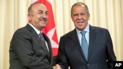 Russian Foreign Minister Sergey Lavrov, right, and his Turkish counterpart Mevlut Cavusoglu shake hands during their meeting in Moscow, Russia, Aug. 24, 2018. 