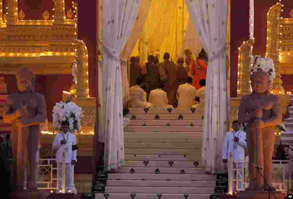 Cambodian King Norodom Sihamoni, facing camera on right in background, son of the late King Norodom Sihanouk, and his mother, Queen Norodom Monineath, behind him, pray inside the crematorium where the body of Sihanouk rests in Phnom Penh, Cambodia, Monday, Feb. 4, 2013. Hundreds of thousands of mourners gathered in Cambodia&#39;s capital Monday for the cremation of Sihanouk, the revered &quot;King-Father,&quot; who survived wars and the murderous Khmer Rouge regime to hold center stage in the Southeast Asian nation for more than half a century. (AP Photo/David Guttenfelder)