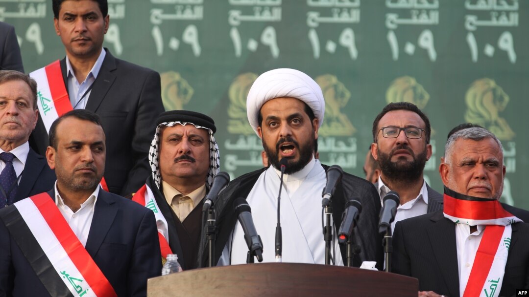 FILE - Qais al-Khazali (C) leader of the Asa'ib Ahl al-Haq, one of the units of the Hashed al-Shaabi (Popular Mobilisation units) gives a speech during a campaign rally for the Fateh Alliance, in Baghdad, May 7, 2018. 