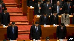 China's top leaders including Chinese President Xi Jinping, bottom center and Chinese Premier Li Keqiang, bottom right, have a moment of silence to commemorate the victims of a slashing spree during the opening session of the Chinese People's Political Consultative Conference in Beijing's Great Hall of the People, China, March 3, 2014.