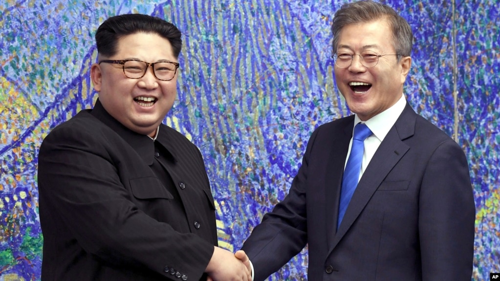 Lãnh tụ Triều Tiên Kim Jong Un (trái) bắt tay Tổng thống Hàn Quốc Moon Jae-in cho báo giới chụp hình bên trong Nhà Hòa bình tại làng đình chiến Panmunjom trong Khu Phi quân sự, ngày 27 tháng 4, 2018.