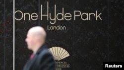 FILE - A security guard walks outside One Hyde Park luxury apartment complex, in London, May 2, 2014. The complex features some of biggest and most expensive properties owned by the world’s billionaires.