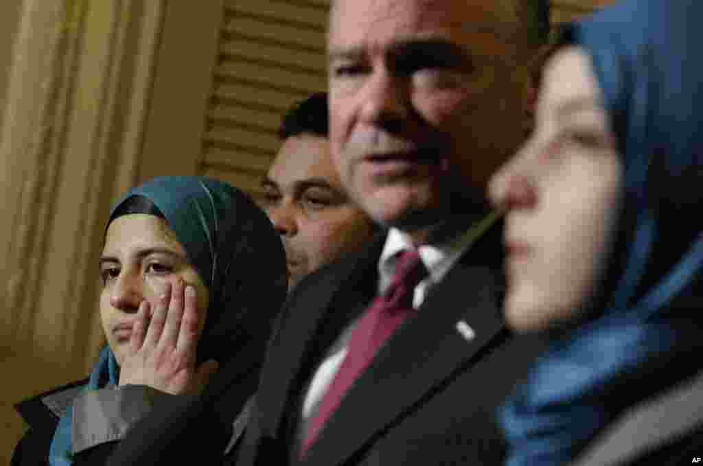 Sen. Tim Kaine, chairman of the Senate Foreign Relations Subcommittee on Near Eastern, Southern and Central Asian Affairs, second from right, speaks as Heba Sawan, left, wipes away tears during a news conference with sister Amineh Sawan, right, and Anas al-Dabas, second from left, on Capitol Hill in Washington, D.C., Feb. 6, 2014. The Sawan sisters were survivors of the August 2013 chemical weapons attack in Moadamiya, Syria, that left more than 1,200 Syrians dead and many more wounded.