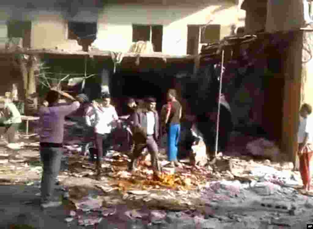 This image made from citizen journalist video posted by the Shaam News Network shows people evacuating a victim of a car bomb attack on a market in the town of Darkoush in Idlib province, Oct. 14, 2013.