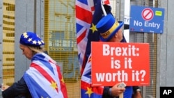 FILE - Anti-Brexit protesters stand outside the International Convention Center in Birmingham during a Conservative Party Conference at the ICC, in Birmingham, England, Oct. 2, 2018.