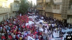 Demonstrators march through the streets in Homs. Britain, France, Germany and Portugal Tuesday circulated a new draft U.N. resolution condemning Syria that drops previous calls for immediate sanctions against Damascus, September 27, 2011.