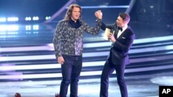 Ryan Seacrest, kanan, mengumumkan Caleb Johnson sebagai pemenang American Idol XIII di Nokia Theatre, Los Angeles (21/5). (AP/Invision/Paul A. Hebert)