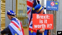 FILE - Anti-Brexit protesters stand outside the International Convention Center in Birmingham during a Conservative Party Conference at the ICC, in Birmingham, England, Oct. 2, 2018.