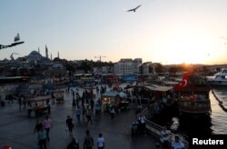 People stroll by the Golden Horn in Istanbul, Turkey, June 11, 2018.