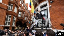 FILE - WikiLeaks founder Julian Assange, center, addresses media and supporters from the balcony of Ecuador's embassy in central London, Feb. 5, 2016.