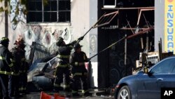 지난 3일 화재가 발생한 미국 캘리포니아 주 오클랜드의 창고에서 소방관들이 진입로를 청소하고 있다.