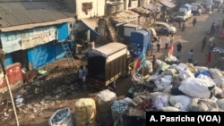 A street along Mumbai's Dharavi slum in India is littered with waste that includes plastic items and bags.