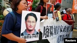 Pro-democracy protesters carry a photo of detained Taiwanese rights activist Lee Ming-Che (L) and other activists during a demonstration in Hong Kong, China, Sept. 11, 2017.