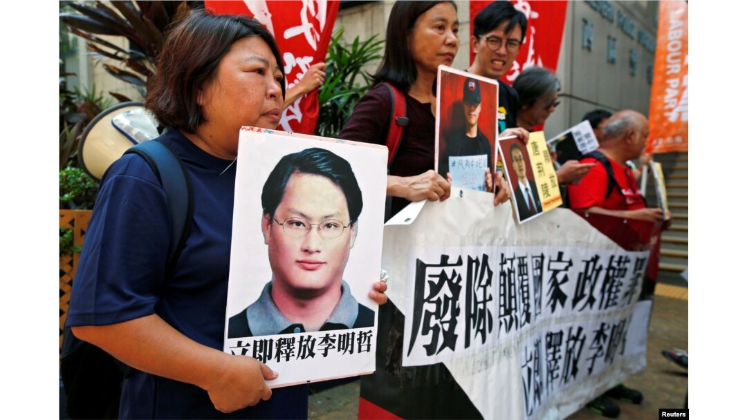 Pro-democracy protesters carry a photo of detained Taiwanese rights activist Lee Ming-Che (L) and other activists during a demonstration in Hong Kong, China, Sept. 11, 2017.