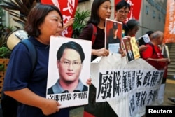 Pro-democracy protesters carry a photo of detained Taiwanese rights activist Lee Ming-Che (L) and other activists during a demonstration in Hong Kong, China, Sept. 11, 2017.