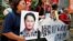 Pro-democracy protesters carry a photo of detained Taiwanese rights activist Lee Ming-Che (L) and other activists during a demonstration in Hong Kong, China, Sept. 11, 2017.