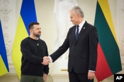 Presiden Lituania Gitanas Nauseda (kanan) berjabat tangan dengan Presiden Ukraina Volodymyr Zelenskyy saat pertemuan di Vilnius, Lituania, Rabu, 10 Januari 2024. (Kantor Pers Kepresidenan Ukraina via AP)