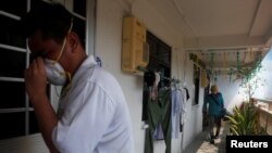 Petugas melakukan 'fogging' atau pengasapan di koridor sebuah perumahan tempat penyebaran kasus Zika ditemukan di Singapura (29/8). (Reuters/Edgar Su) 