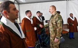 This handout photo provided Nov. 11, 2020, by the Azerbaijan's Presidential Press Office shows President Ilham Aliyev during his meeting with servicemen undergoing treatment at the Clinical Medical Center No. 1 in Baku, Azerbaijan.