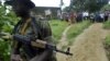 FILE - Local villagers watch a Nigerian soldier in the southern Bakassi Peninsula, near the Cameroon and Nigeria border, Aug. 14, 2006. Trade between the two countries was halted in the area on Oct. 9, 2024, after two Cameroon officials were abducted.