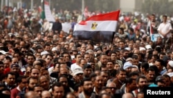 FILE - A man holds an Egyptian flag during a rally at Tahrir Square, in Cairo, Feb. 25, 2011. 