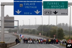 People block the highway leading to Calais and the Channel tunnel in Calais, northern France, Sept. 5, 2016.